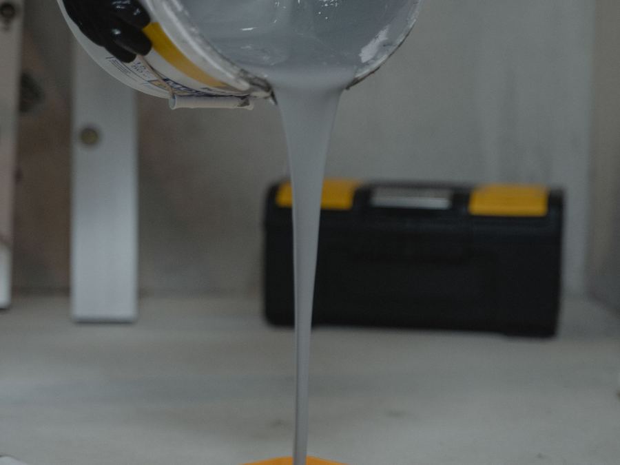 Gray coating being poured into a roller tray